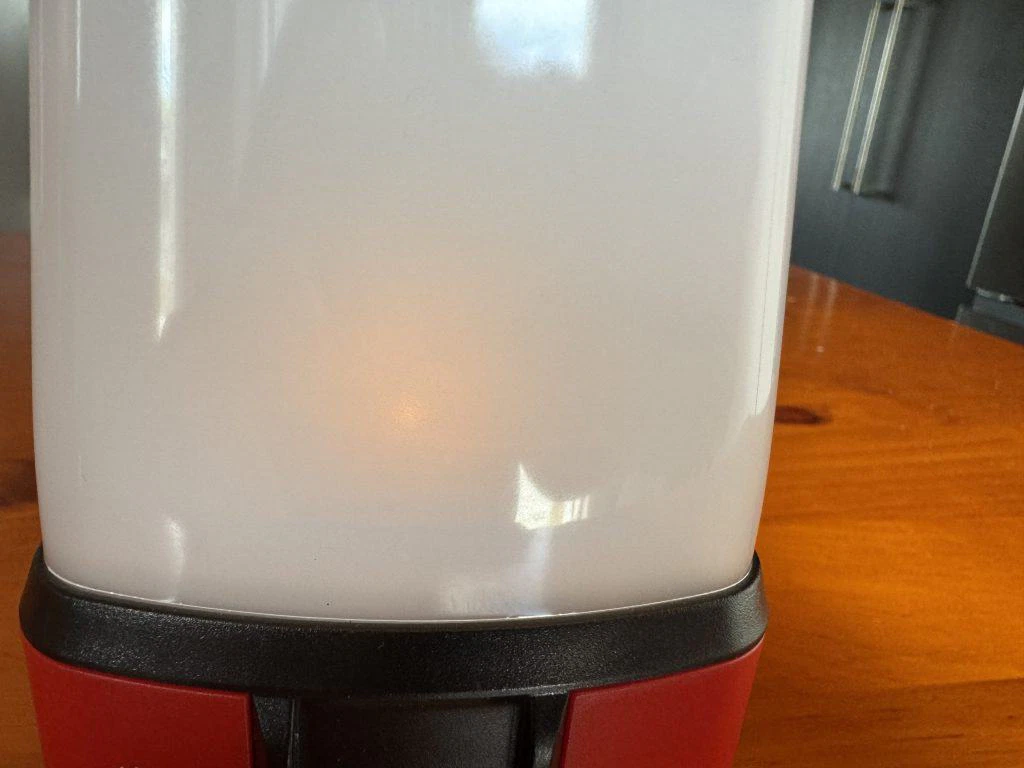 A red and black lantern sitting on top of a table.